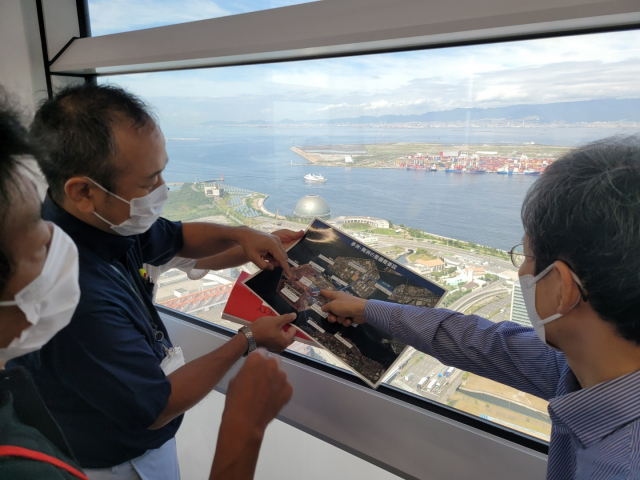 오사카시 관계자들이 오사카부 청사에서 2025오사카간사이엑스포 박람회장인 유메시마 조성 과정을 설명하고 있다. 멀리 보이는 인공섬 유메시마에는 현재 막바지 지반 조성 공사가 한창 진행되고 있다. 김영한 기자 kim01@