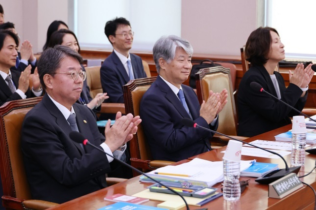 이종석 헌법재판소장이 11일 오전 국회 법제사법위원회의 헌법재판소 등에 대한 국정감사에서 정청래 위원장의 제안으로 위원, 증인들과 함께 한강의 노벨문학상 수상을 축하하는 박수를 치고 있다. 왼쪽부터 김정원 헌법재판소 사무처장, 이종석 헌법재판소장, 지성수 헌법재판연구원장. 연합뉴스