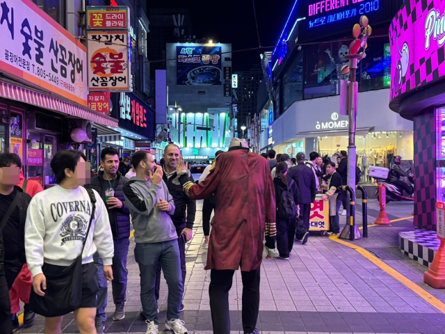 31일 오후 10시께 부산 부산진구 서면 젊음의거리 일대 모습. '목 잘린 좀비' 분장을 한 코스튬 플레이어가 행인들에게 인사를 하고 있다. 손희문 기자