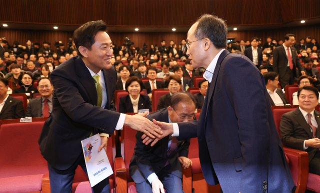 오세훈 서울시장이 12일 서울 여의도 국회 도서관에서 열린 '87체제 극복을 위한 지방분권 개헌 토론회'에 참석해 국민의힘 추경호 의원과 인사를 나누고 있다. 연합뉴스