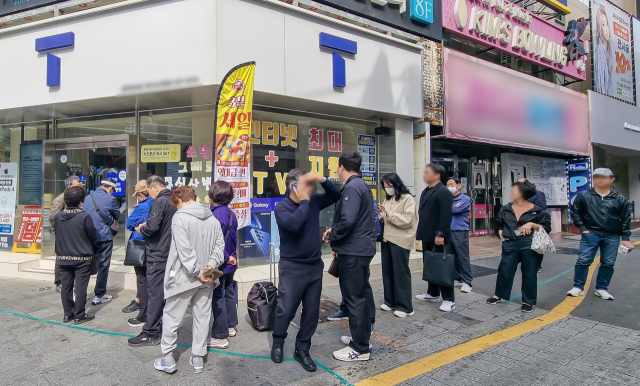 가입자 유심(USIM) 정보를 탈취당한 SK텔레콤이 유심 무료교체 서비스를 시작한 지 이틀째인 29일 부산 시내 한 SKT 대리점 앞에서 시민들이 줄을 서 기다리고 있다. 김종진 기자 kjj1761@