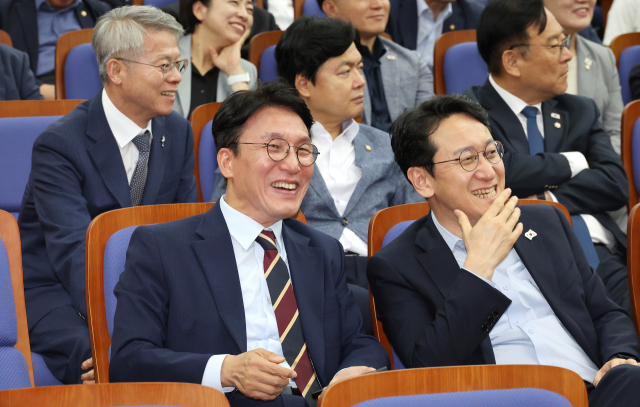 김민석(왼쪽) 국무총리 후보자가 13일 국회에서 열린 더불어민주당 원내대표 선출 의원총회에 참석해 후보들의 정견발표를 들으며 밝은 표정을 하고 있다. 연합뉴스