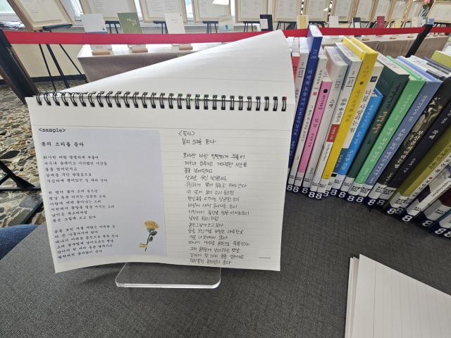 전시회 한쪽 책상에는 시를 필사할 수 있는 노트가 준비돼 있다. 김효정 기자