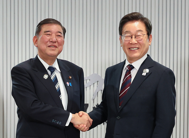 이재명 대통령이 17일(현지 시간) 캐나다 앨버타주 캐내내스키스 주요 7개국(G7) 정상회의장에서 열린 한일 정상회담에서 이시바 시게루 일본 총리와 악수하며 기념촬영을 하고 있다. 연합뉴스