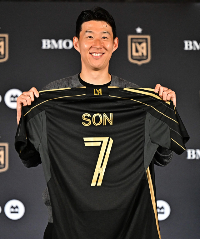 미국프로축구(MLS) 로스앤젤레스FC에 이적한 손흥민이 토트넘 홋스퍼 시절 등번호가 적힌 LAFC 유니폼을 들고 웃고 있다.AFP연합뉴스