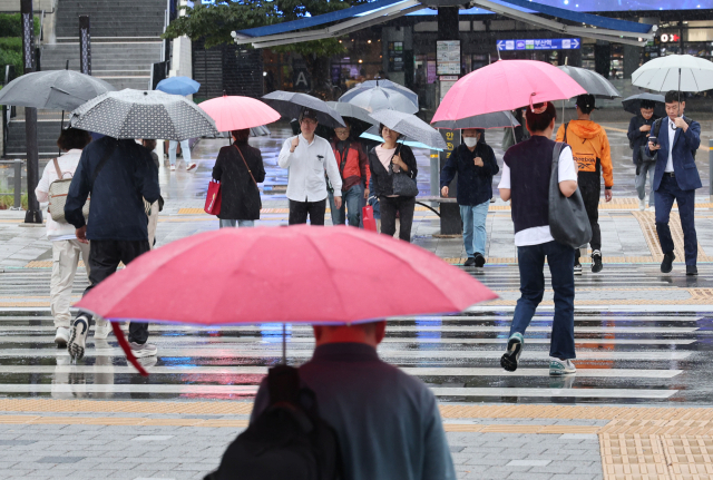 가을비가 내리며 흐린 날씨가 이어진 지난 14일 오전 부산 동구 부산역 앞에서 시민들이 우산을 쓰고 횡단보도를 지나가고 있다. 정종회 기자 jjh@