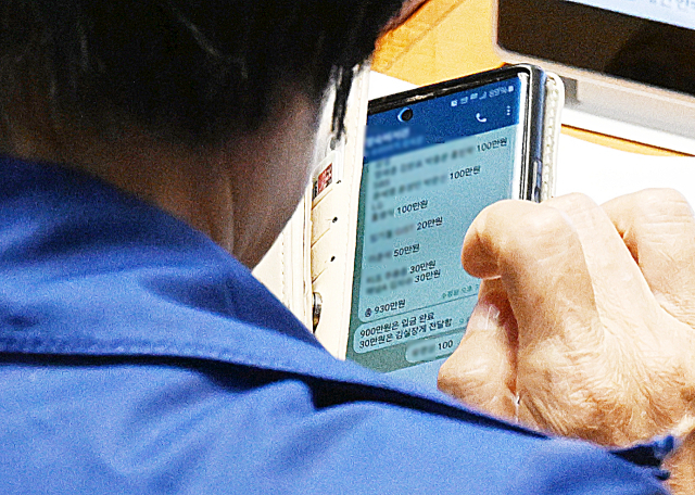 국정감사 기간 딸 결혼식으로 논란을 빚은 국회 과학기술정보방송통신위원장인 더불어민주당 최민희 의원이 26일 국회 본회의장에서 축의금과 관련한 텔레그램 메시지를 보고 있다. 대기업, 언론사 이름과 금액이 적혀 있는 이 메시지는 최 위원장이 축의금을 돌려주는 과정 중 보좌진과 주고받은 내용으로 추정된다. 연합뉴스