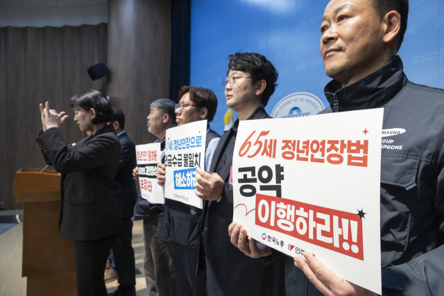 5일 국회에서 진보당 윤종오 의원과 한국노총, 민주노총이 주최한 65세 법정 정년 연장 입법 연내 촉구 기자회견 참석자들이 손팻말을 들고 있다. 연합뉴스