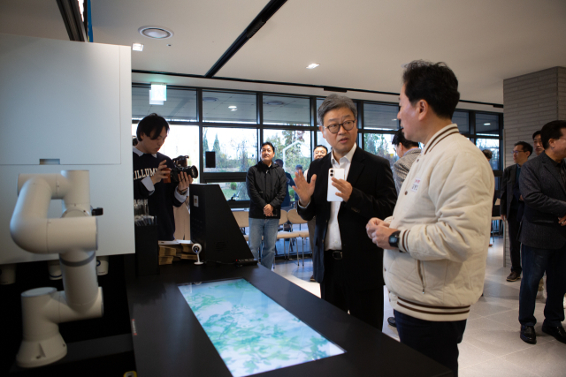 지난 16일 수자인 아파트 커뮤니티센터에서 김형찬(오른쪽) 강서구청장이 바리스타 로봇에 대한 설명을 듣는 모습. 부산시 제공