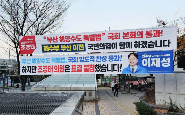 2일 부산 사하구에 국민의힘 조경태(사하을) 의원이 해양수산부 이전을 지원하는 특별법 국회 본회의 통과 홍보 현수막을 내걸자 더불어민주당 이재성 사하을 지역위원장이 그 아래 조 의원을 직격하는 현수막을 걸었다.