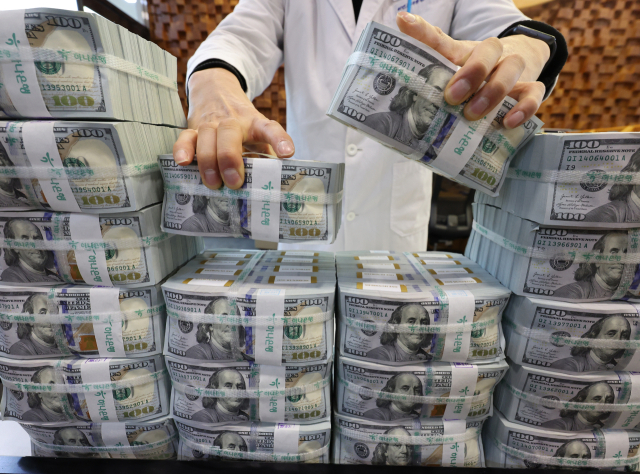 원/달러 환율 고공행진으로 시장의 우려가 커지는 가운데 외환 당국과 국민연금은 연간 650억달러 규모의 외환스와프(FX Swap) 계약을 1년 연장하기로 지난 15일 합의했다. 16일 서울 중구 하나은행 위변조대응센터에서 직원이 달러화를 정리하고 있다. 연합뉴스