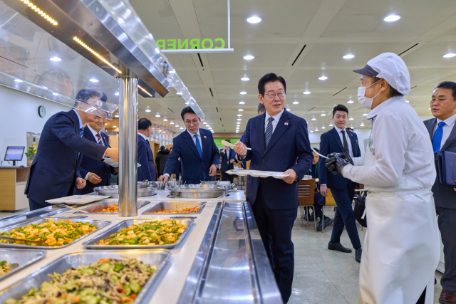 이재명 대통령이 19일 정부서울청사 별관에서 통일부·외교부 업무보고를 마친 뒤 식사를 위해 방문한 구내식당에서 직원들과 인사하고 있다. 연합뉴스