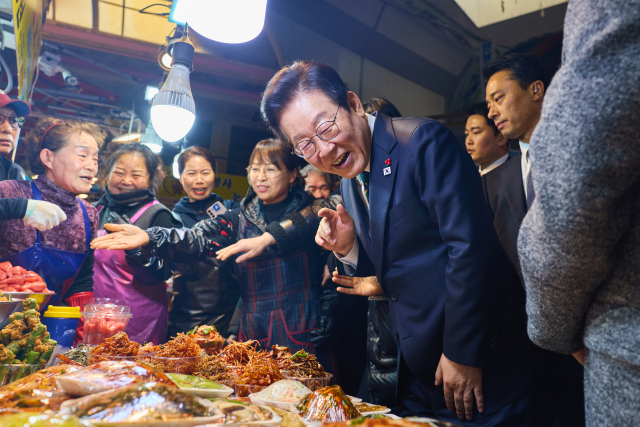 이재명 대통령이 23일 해양수산부 청사에서 국무회의를 마친 뒤 부산 부산진구 부전시장을 찾아 상인들과 이야기를 나누고 있다. 연합뉴스