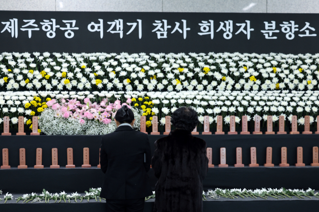12·29 무안공항 여객기 참사 1주기를 하루 앞둔 28일 전남 무안국제공항 1층 합동 분향소에서 추모객들이 헌화하고 있다. 연합뉴스
