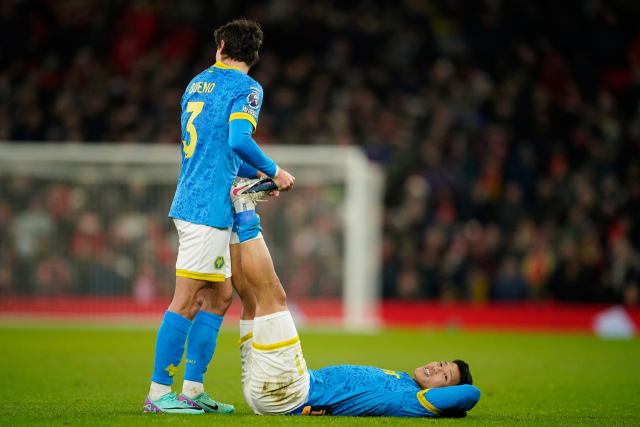 다리 근육 통증으로 그라운드에서 동료의 치료를 받는 황희찬. AP연합뉴스