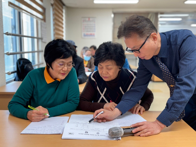 한병철(오른쪽) 씨가 부산시노인종합복지관에서 검정고시 강의를 하고 있는 모습.