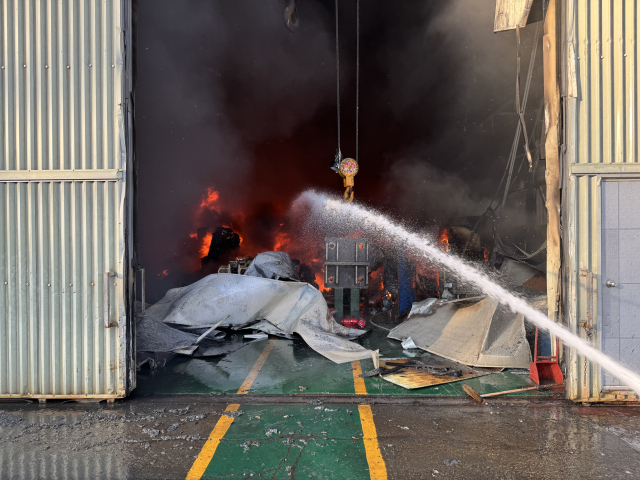 4일 오후 울산 울주군 온산읍의 한 산업용 배관 제작 공장에서 불이 나 소방대원들이 호스로 진화 작업을 벌이고 있다. 울산소방본부 제공