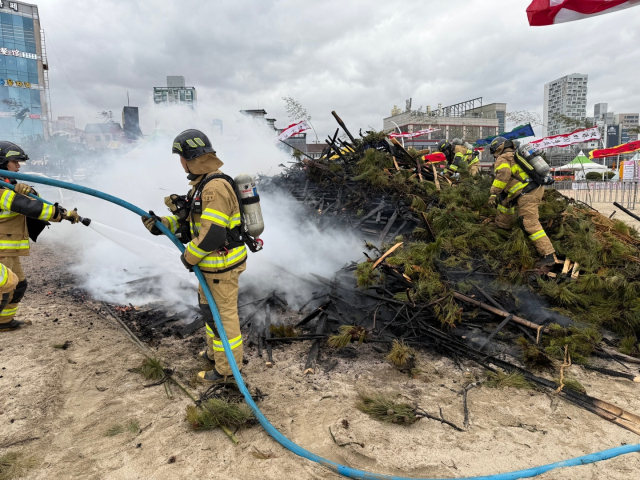 지난 1일 오후 울산 동구 일산해수욕장에 설치된 달집 더미에서 불이 나 소방대원들이 진화 작업을 벌이고 있다. 울산소방본부 제공