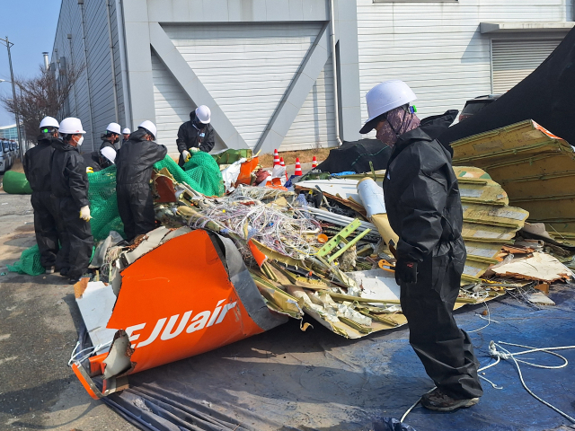 12일 국토교통부와 항공철도사고조사위원회, 전남과학청 과학수사대 관계자들이 무안국제공항 공항소방대 뒤편에 보관된 여객기 잔해를 조사하고 있다. 연합뉴스