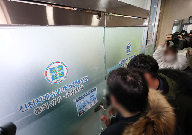 통일교·신천지의 정교 유착 의혹을 수사하는 검·경 합동수사본부가 ‘당원 가입 의혹’을 받는 신천지에 대한 강제수사에 착수했다. 지난 1월 30일 경기도 과천시 신천지 총회 본부에서 한 관계자가 내부로 들어서고 있다. 연합뉴스