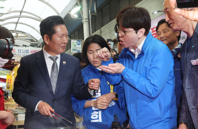 더불어민주당 정청래 대표와 하정우 부산 북갑 국회의원 보궐선거 후보가 3일 오전 부산 북구 구포시장에서 고기를 시식하고 있다. 정종회 기자 jjh@