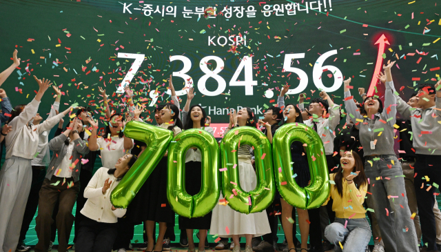 코스피가 ‘7000피’라는 새 역사를 썼다. 6000포인트 돌파 후 47거래일 만이다. 코스피가 전장보다 447.57포인트(6.45%) 오른 7384.56으로 마감한 6일 오후 서울 중구 하나은행 딜링룸에서 직원들이 축하 세리머니를 하고 있다. 연합뉴스