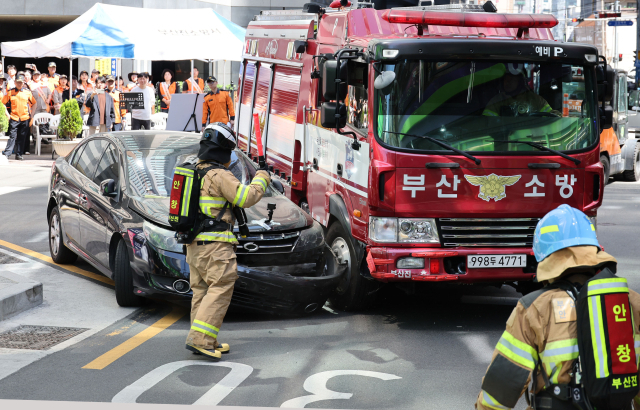 13일 부산 부산진구 범천동의 한 이면도로에서 부산소방재난본부의 긴급출동 통행 방해 불법 주·정차 차량 강제처분 훈련이 열렸다. 소방차량이 출동로 확보를 위해 불법으로 주정차된 차량을 강제로 돌파하고 있다. 이재찬 기자 chan@
