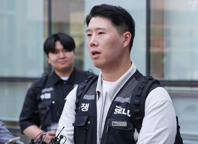 최승호 초기업노조 삼성전자지부 위원장이 13일 경기도 수원시 영통구 수원지방법원에서 열린 삼성전자가 노조를 상대로 제기한 위법 쟁의행위 금지 가처분 신청 심문을 마치고 나와 취재진 질문에 답하고 있다. 연합뉴스