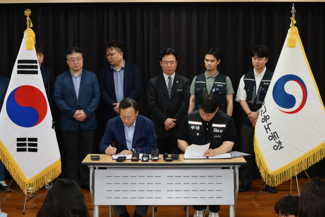 20일 경기도 수원시 장안구 경기고용노동청에서 열린 삼성전자 임금협상을 마친 후 여명구 삼성전자 DS(디바이스솔루션·반도체사업담당) 피플팀장과 최승호 삼성그룹 초기업노동조합 삼성전자지부 위원장이 잠정합의안에 서명하고 있다. 연합뉴스