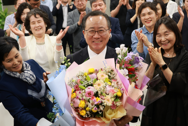 김석준 부산시교육감 후보가 3일 오후 부산 부산진구 선거사무소에서 당선이 확실시되자 꽃다발을 들고 환하게 웃고 있다. 연합뉴스