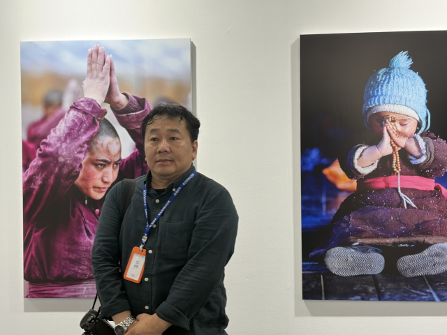 주제전 ‘Being Human'(다시, 사람)에 참여한 남준 작가와 그의 작품. 사진가 남준은 티베트, 북인도 라다크, 네팔 등 아시아의 오지를 15년 넘게 직접 걸으며 그곳 사람들의 신앙과 일상을 묵묵히 기록해 왔다. 김은영 기자 key66@