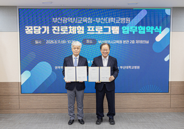 김해영(왼쪽) 부산대병원장과 김석준 부산시교육감이 11일 ‘꿈담기 진로체험 프로그램’ 운영을 위한 업무협약을 체결한 뒤 기념촬영을 하고 있다. 부산대병원 제공