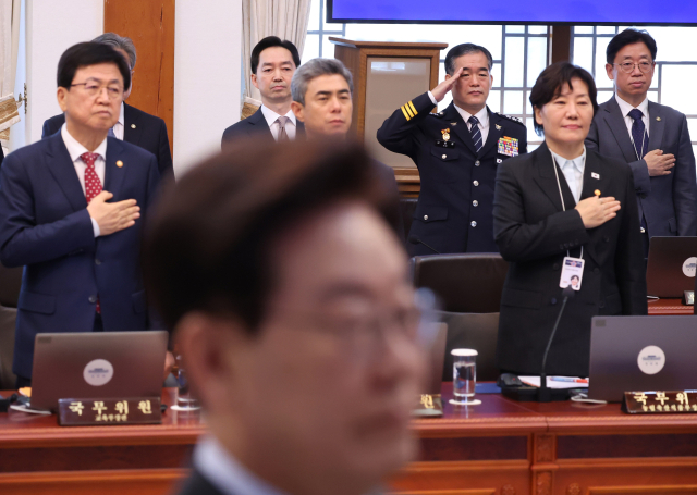 김지용 중대범죄수사청장과 김종철 경찰청장 직무대행 등이 27일 이재명 대통령 주재로 청와대에서 열린 국무회의에서 국기에 경례하고 있다. 연합뉴스
